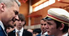 Ein Junger Farbstudent im Gespräch mit Ex-Bundeskanzler Karl Nehammer.