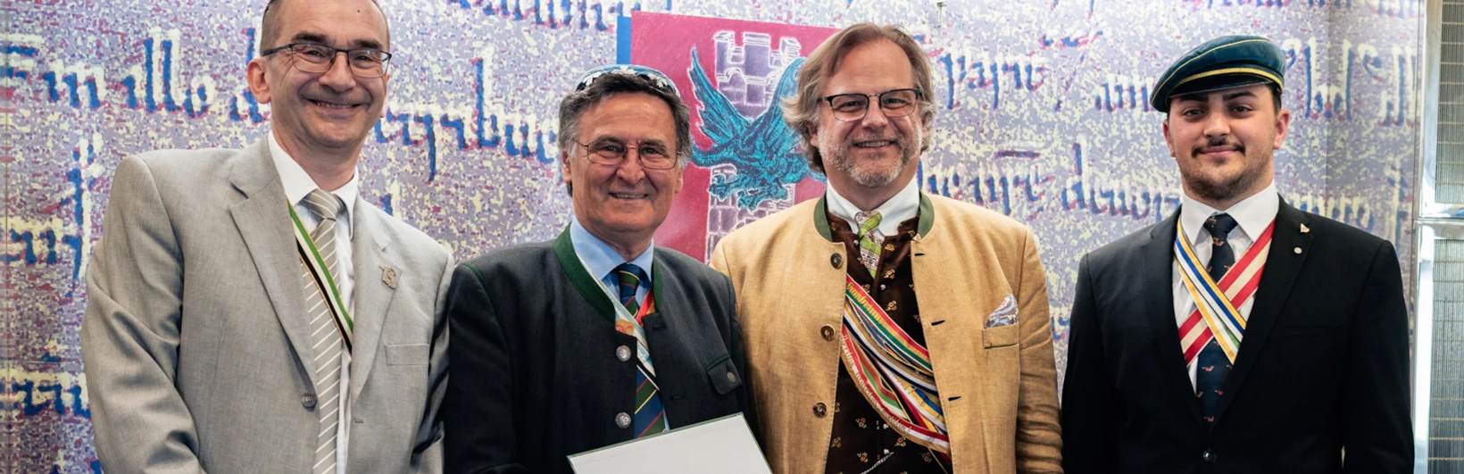 Junge Männer mit Band und Deckel unterhalten sich lachend.