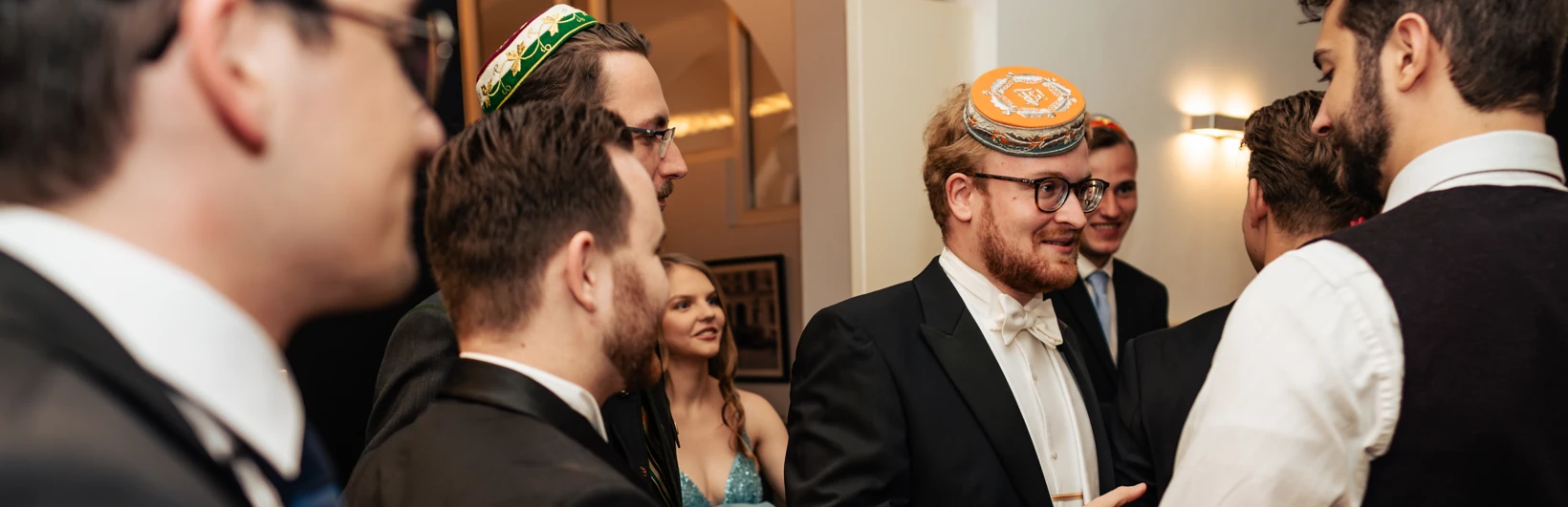 Junge Männer mit Band und Deckel unterhalten sich lachend.